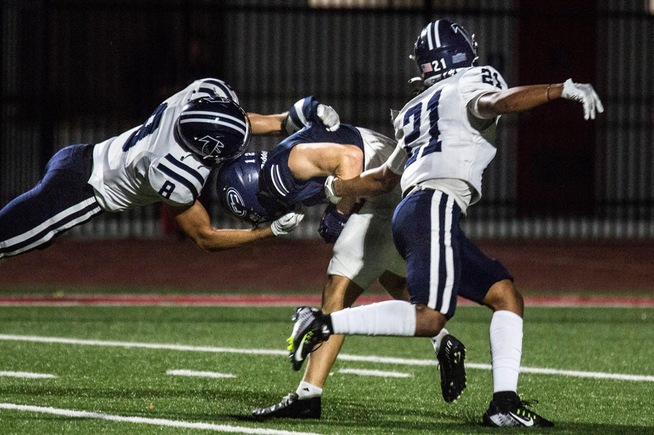 Arna Bontemps (8) and Zedekiah Rodriguez-Brown (21) converge on a tackle against Fullerton