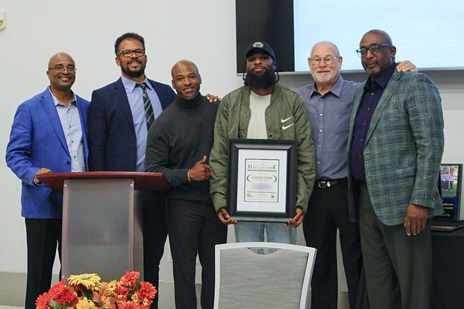Ameer Webb (with plaque) is joined by the Falcons coaching staff after receiving his Hall of Fame Award
